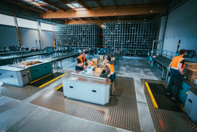 Operators at work with the Exotec sequencing buffer during automatic palletising