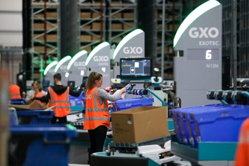 Robot e operatori nelle attività di preparazione degli ordini nel centro GXO Guess